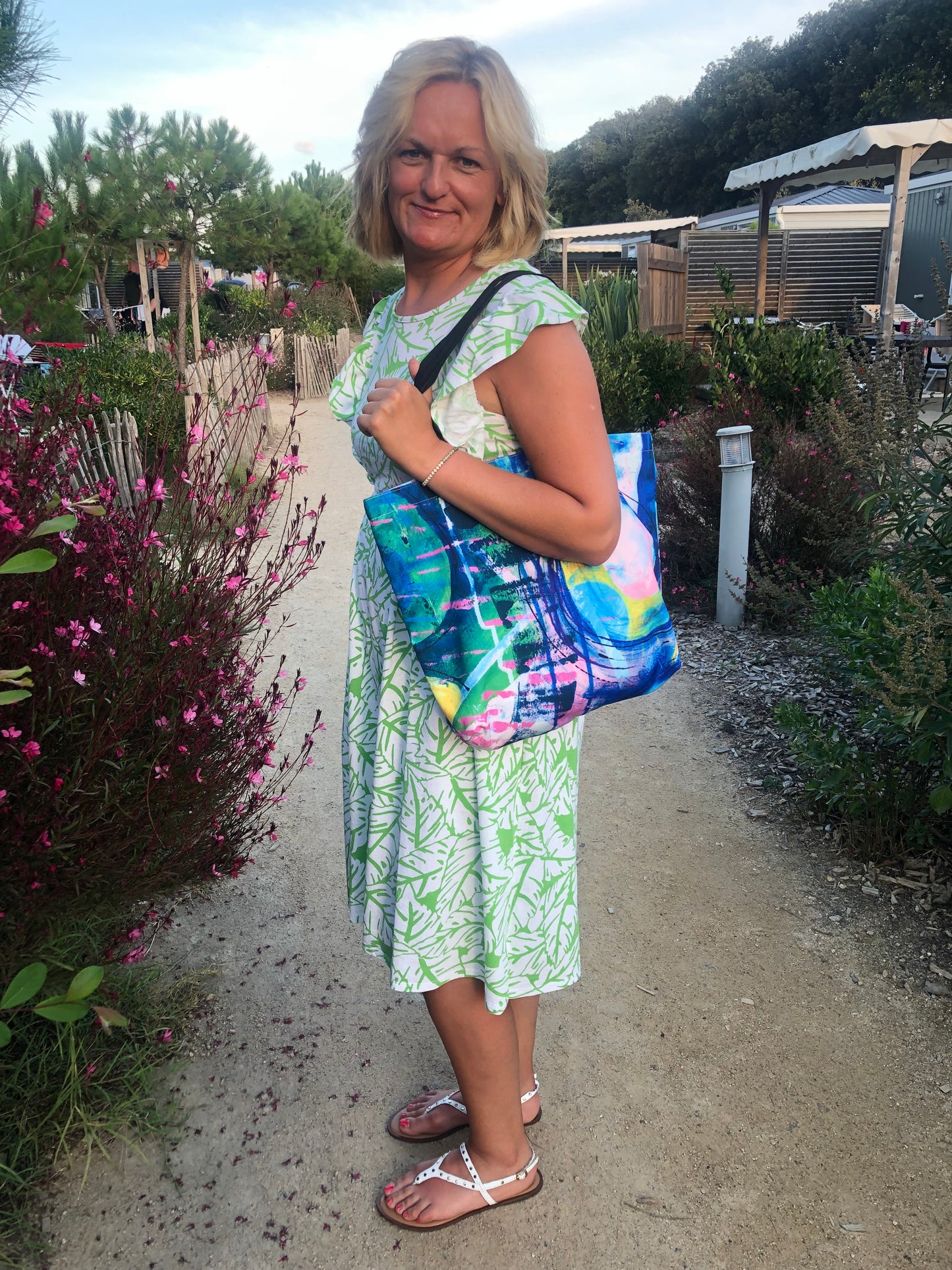 Woman in summer dress carrying Awakening tote bag with colourful, abstract design