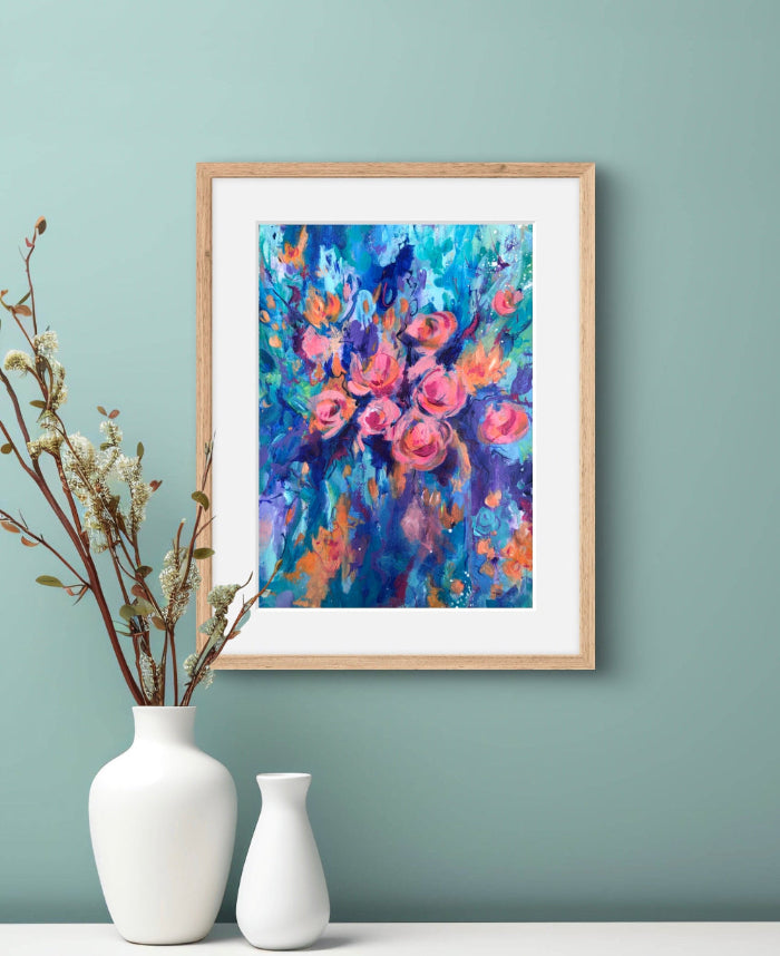 Framed floral painting on a light green wall with two white vases below.