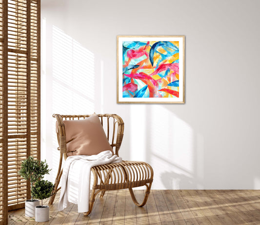 Adventure colourful abstract art print displayed in a natural wood frame on a white wall next to a bamboo chair and wooden window shutters.