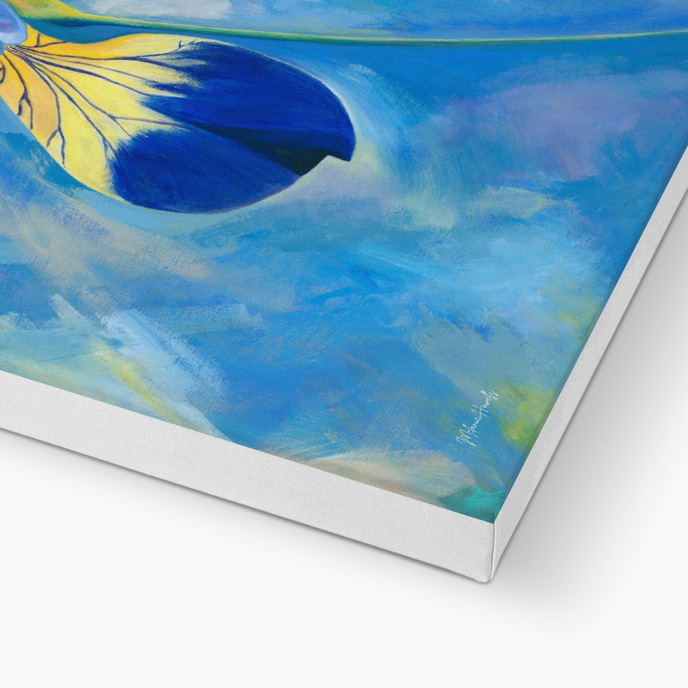 Artist signature shown on the corner of a printed canvas featuring a flower petal in blue and yellow colours on a painterly blue background.