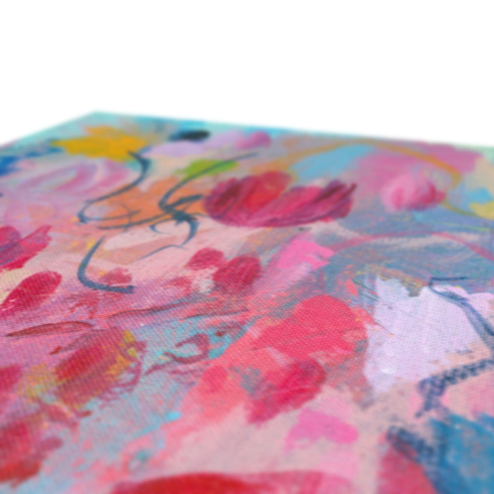 Abstract floral canvas painting with expressive brushstrokes in pink, red, blue, yellow, and white, shown close-up on a white background.