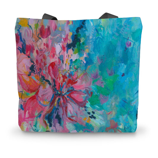 A colourful canvast tote bag featuring a bright floral design in pinks, turquoise and green