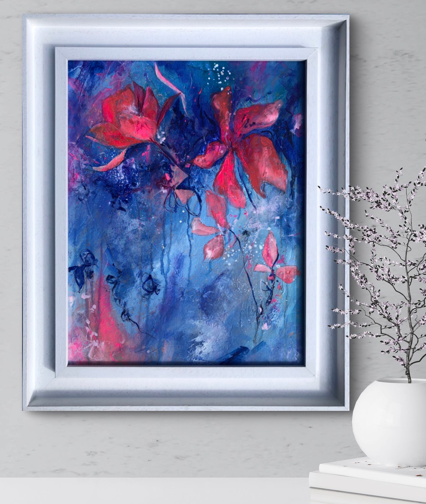 Pink flowers painted against a textured and atmospheric blue ground, framed in a white wooden frame.