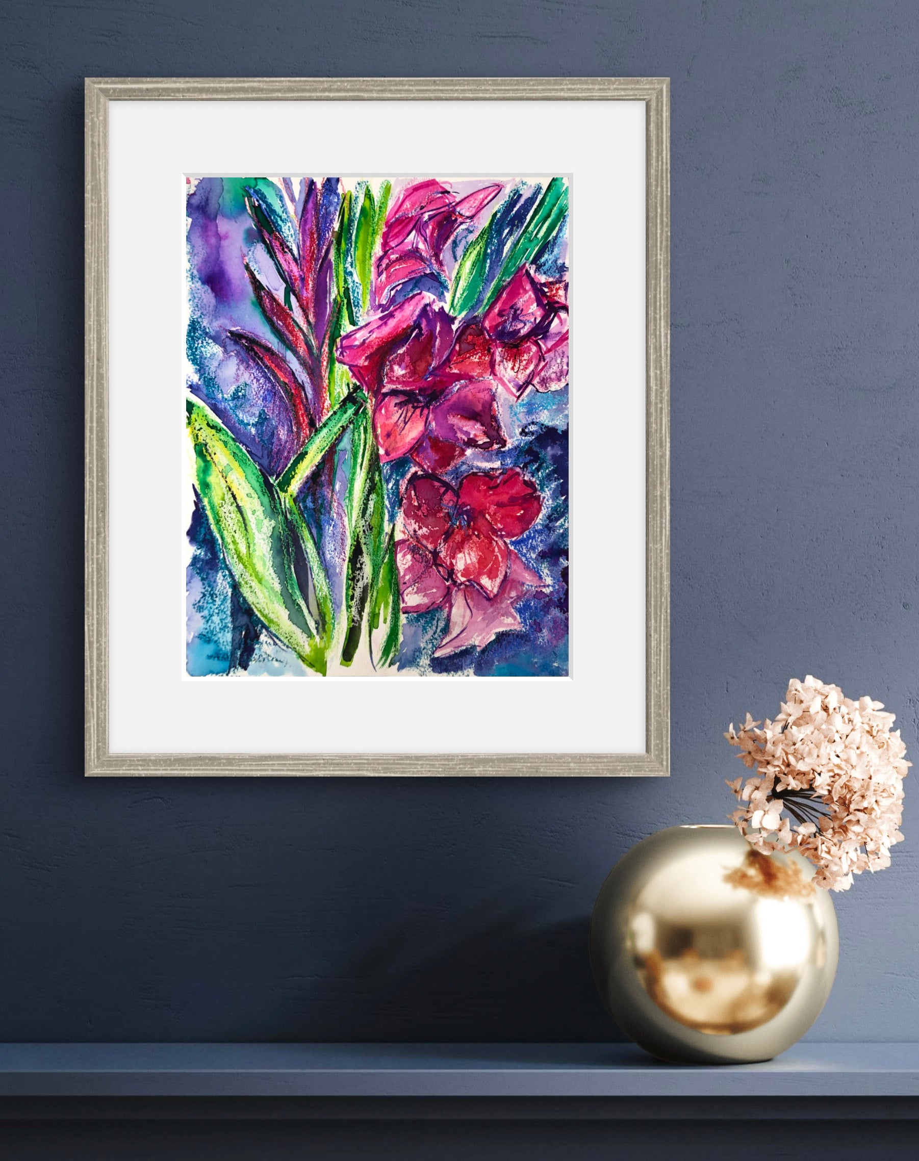 Watercolour painting of pink gladioli flowers, framed and displayed against a dark blue wall. 