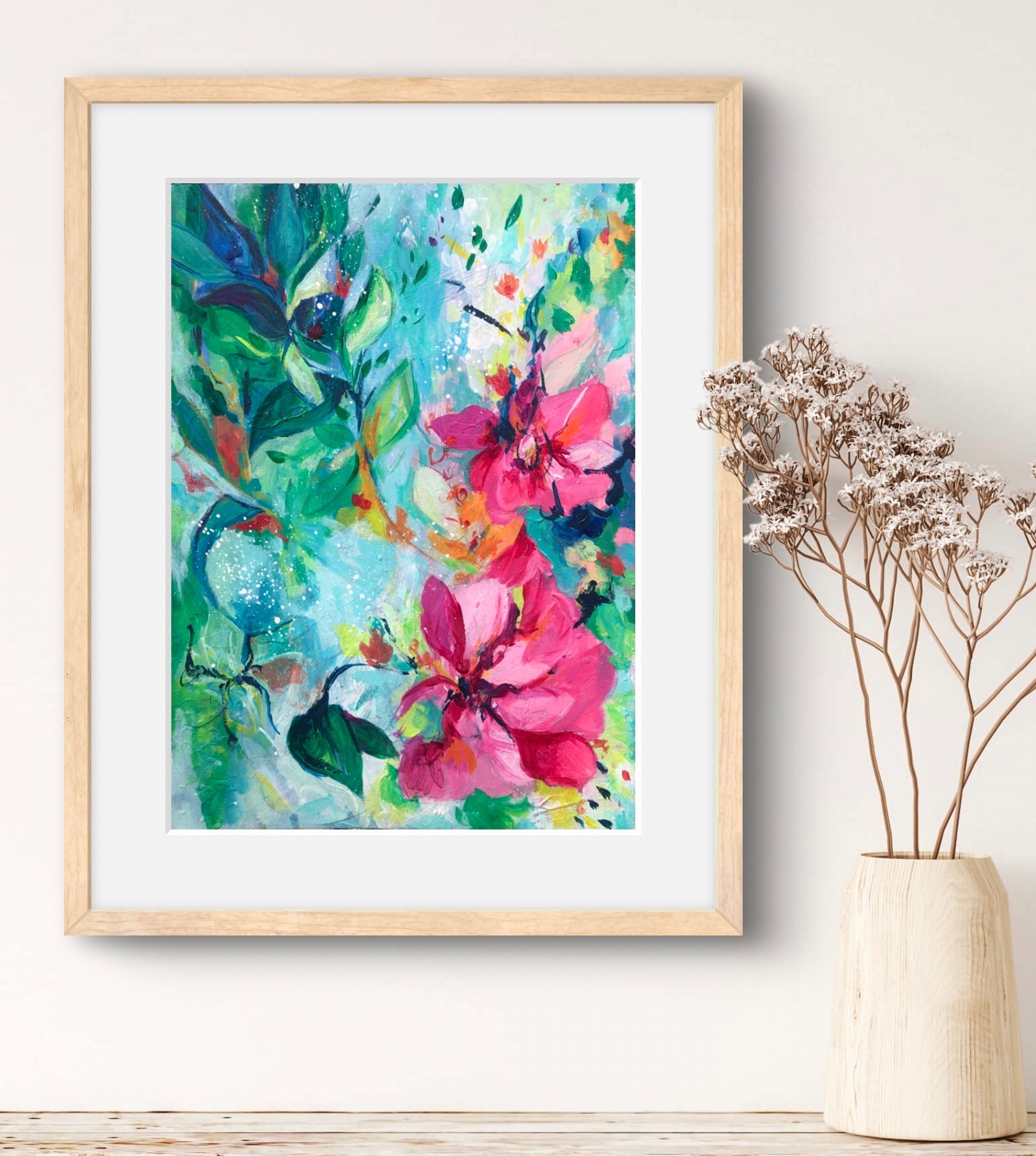 Art print of pretty pink flowers against a lush aqua and green background, framed in a natural wood frame.