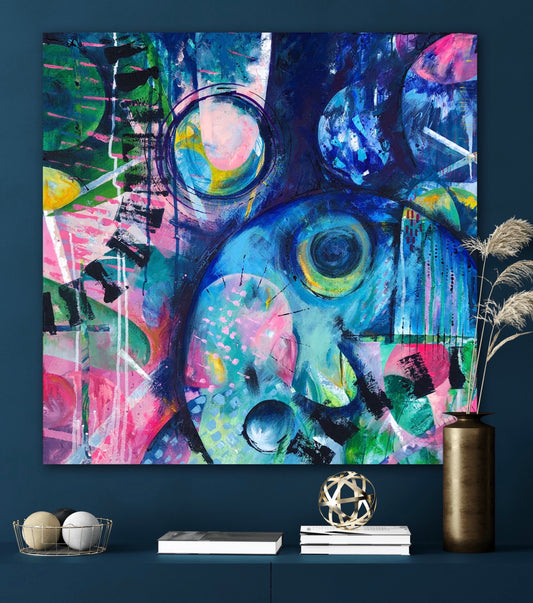 Colourful abstract acrylic painting on stretched canvas called Awakening. Measures 60x60cm and features shades of pink, blue and green. Displayed on a navy wall.