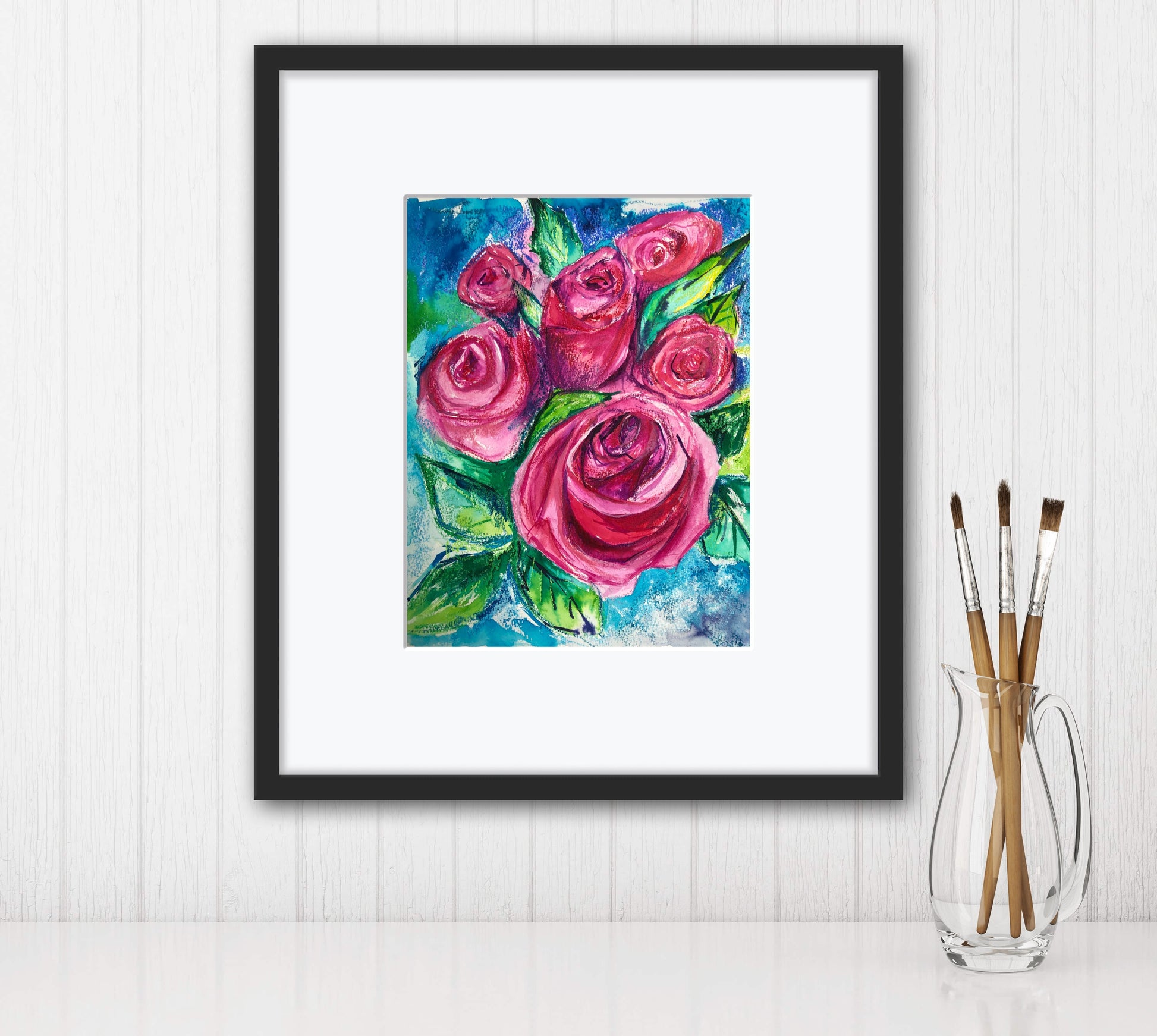 Rosey Blooms original vibrant painting shown framed with a white mount and simple black frame against a white panelled wall. 