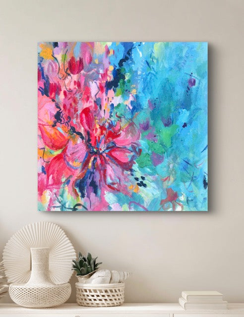 Colourful floral abstract printed canvas in pinks and turquoise against a plain wall