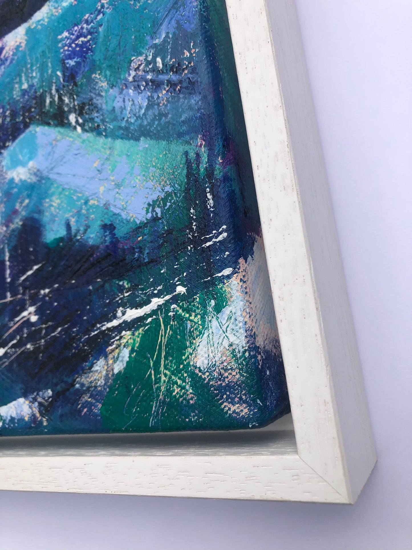 Close-up frame detail of Tranquility, a painting on canvas in a white tray frame