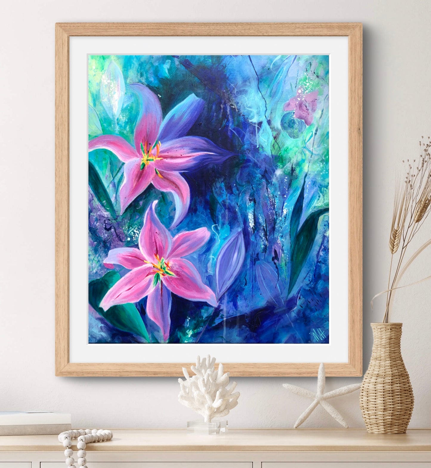 Framed pink and blue floral print in a natural frame