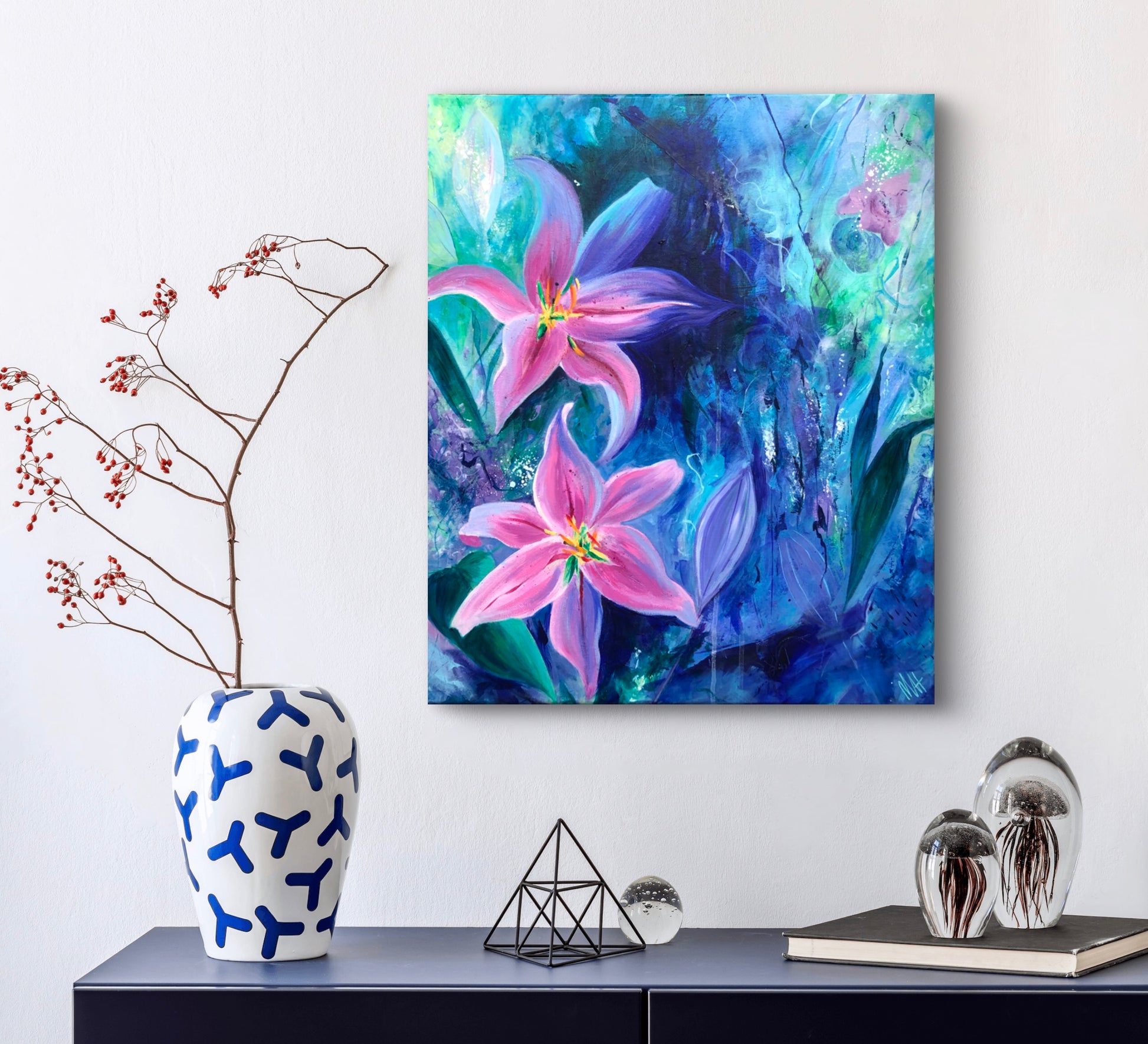 Abstract floral painting of pink florals with botanical elements against a rich blue and green background, displayed against a white wall.