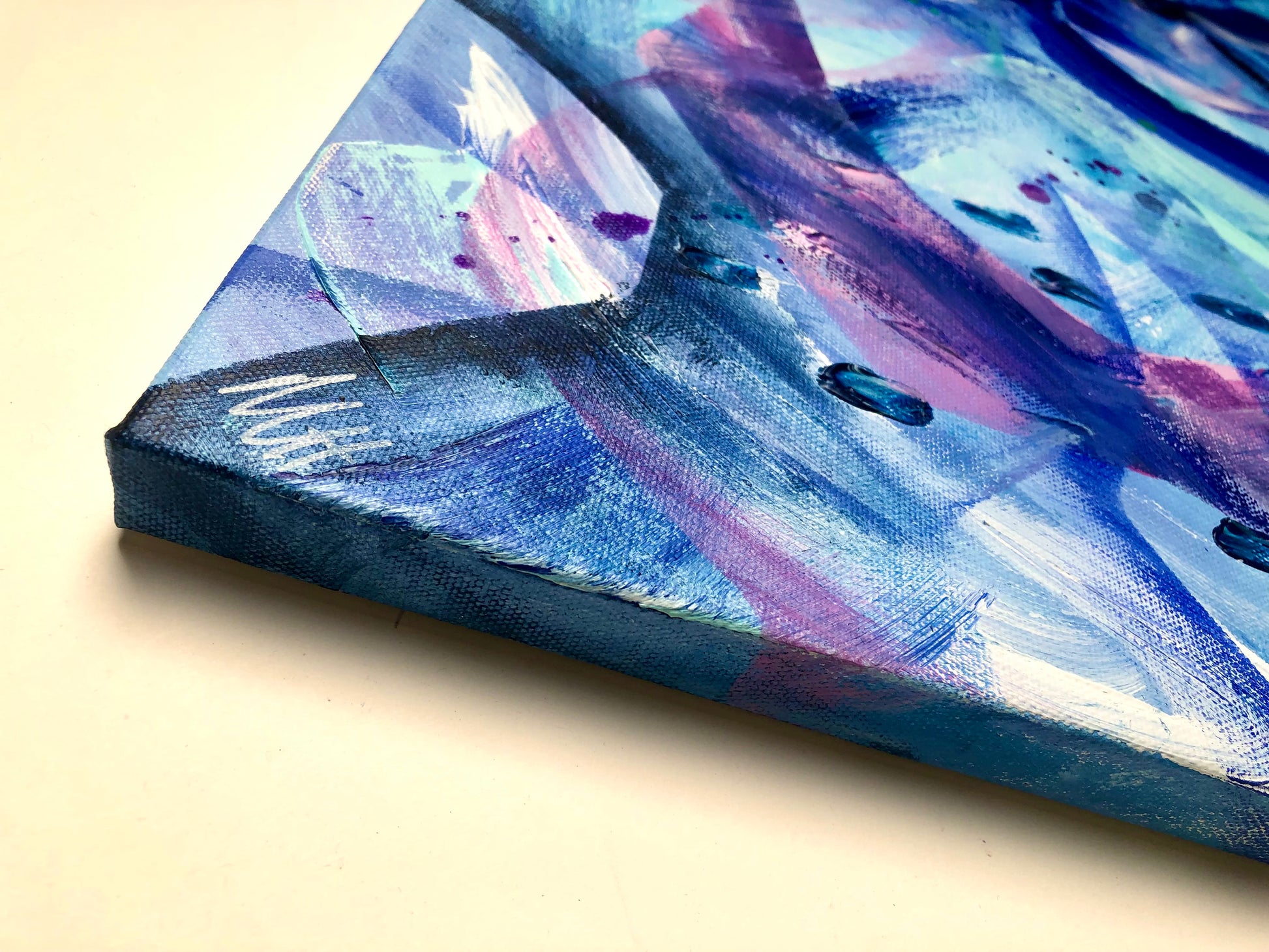 Close-up of painting frame and artist's signature from an original acrylic painting in shades of blue and purple