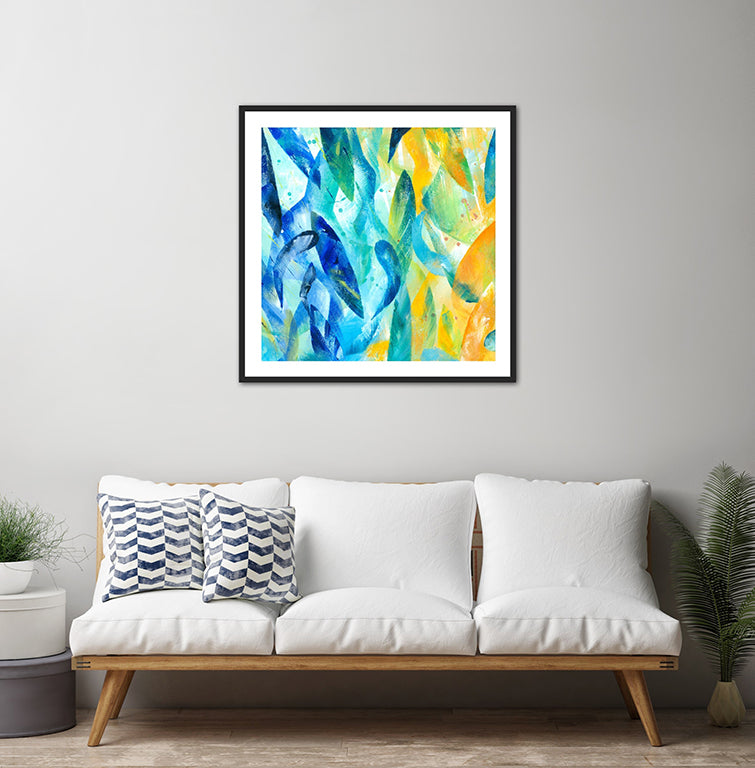 Synergy art print displayed in a black frame on the pale grey wall of a contemporary room above a modern sofa